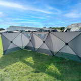 Photo of holawild blackthorn 4.0 poled windbreak on field alongside other family tunnel tents with blue sky.